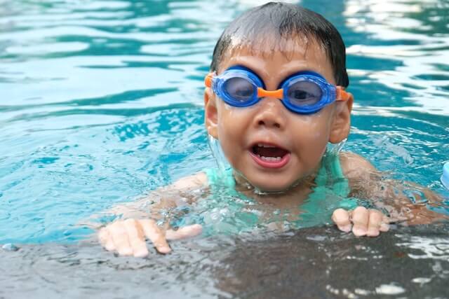 A boy swimming in a pool who needs kids meals on the go.