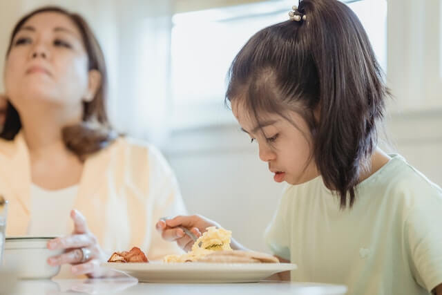 Picky eater having a meal with her frustrated mother